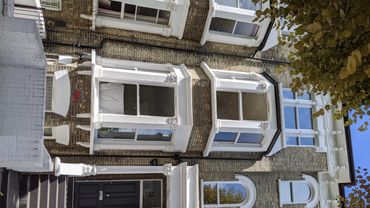 Classic brick townhouse with bay windows and white trim.