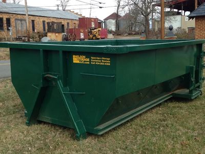 Green Nelson Storage open-top roll-off dumpster sits at a job site