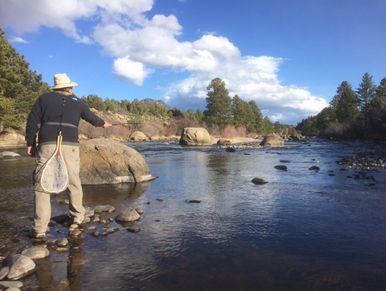 Man fly fishing on the Arkansas River on a sunny day.