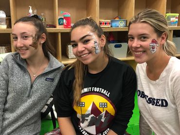 Three girls with face paint smiling.