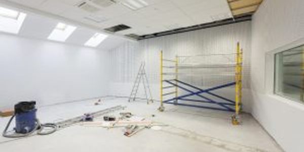 Drywall installation in a new office, with scaffolding and ladder shown.