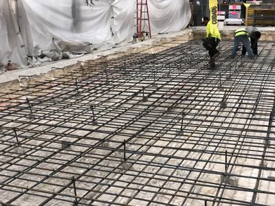 Concrete flooring work begins as rebar is put in place for at a big Curtis 1000 warehouse.