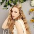 girl in wedding dress sat on chair with long blonde wavy hair with star hair pin and flowers 