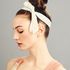 girl with hair up in a bun with a cream ribbon tied in a bow