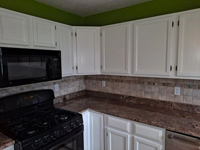 This is the finished kitchen with new paint for the cabinets as well as a vibrant color for the wall