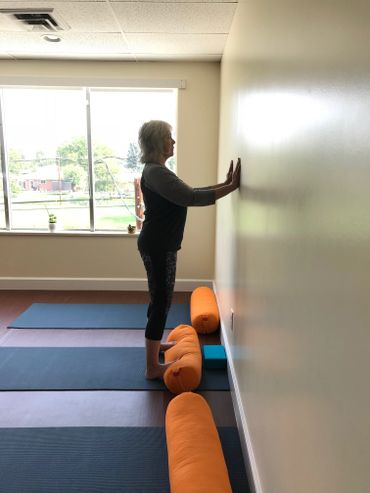 One student in a standing pose facing the wall at Kaiut Yoga Broomfield Studio