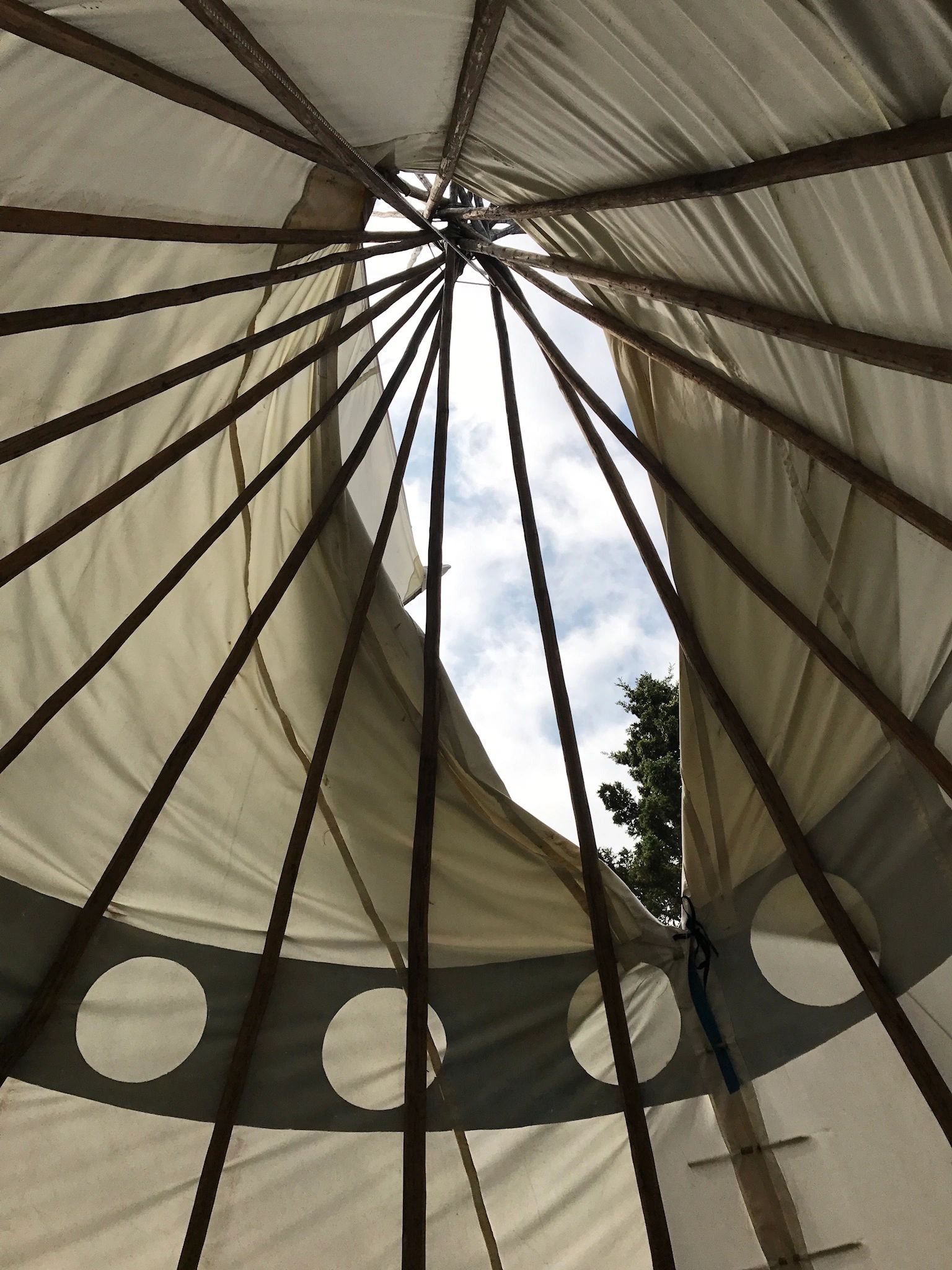 photo from the inside of a teepee looking up to the sky