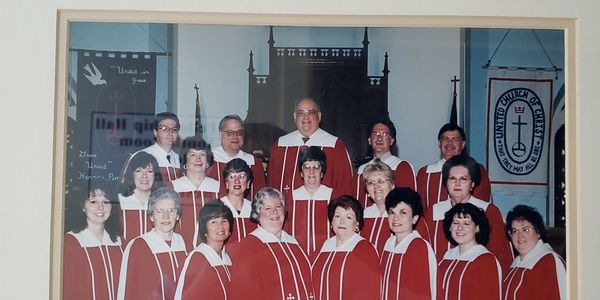 Church choir group dressed in red and white robes posing for a photo.
