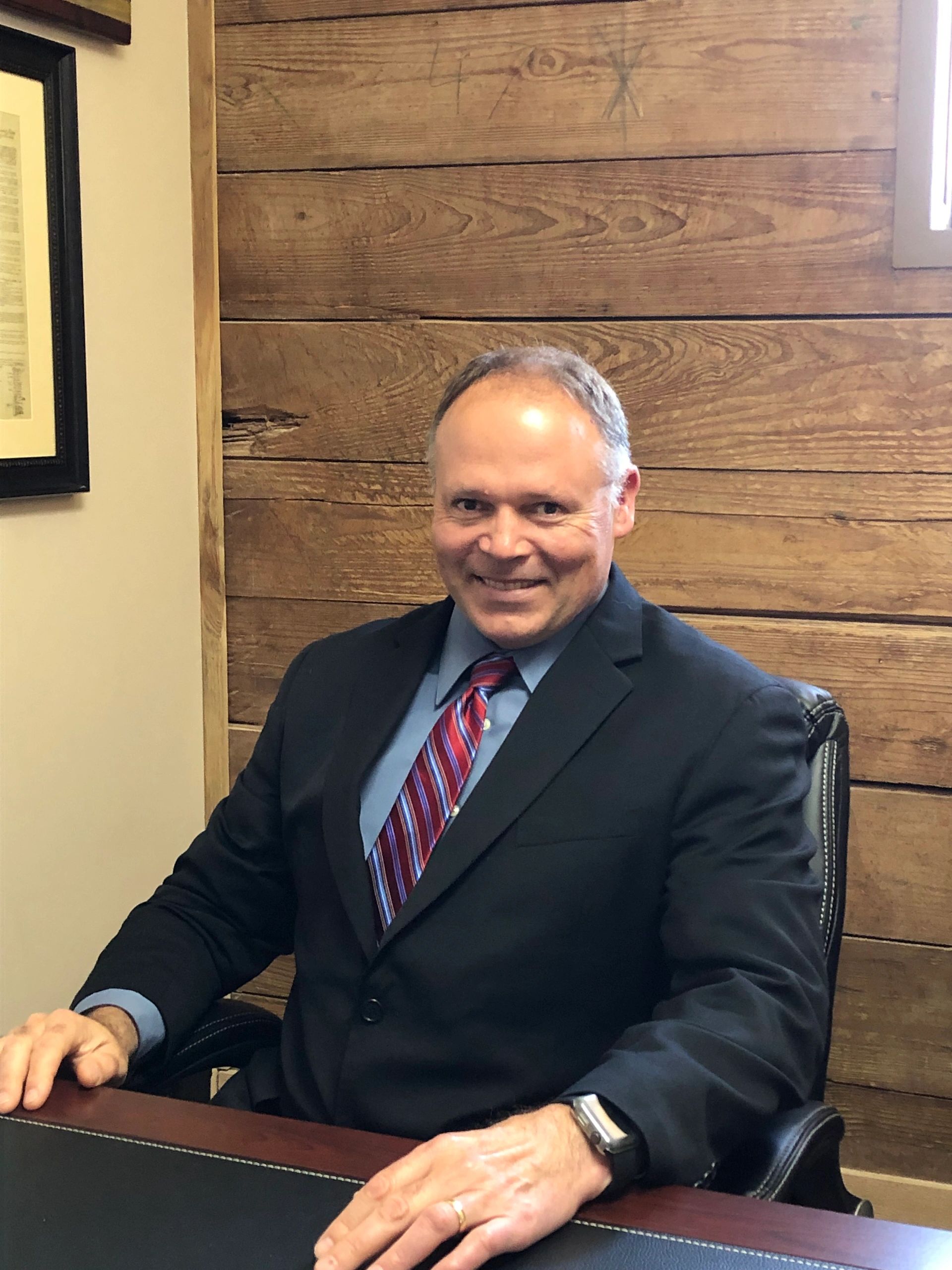 photo of smiling man at a desk