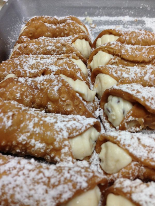Tray of Cannolis dusted with powdered sugar