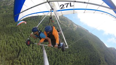 A hang gliding tandem lesson with a paraglider in the background
