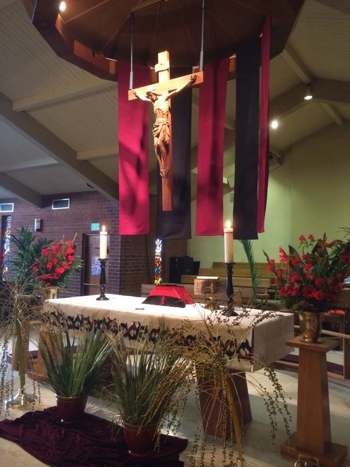 Church altar decorated with flowers, candle lights and Jesus at the cross