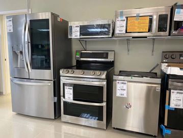 A display of stainless steel kitchen appliances in a store.