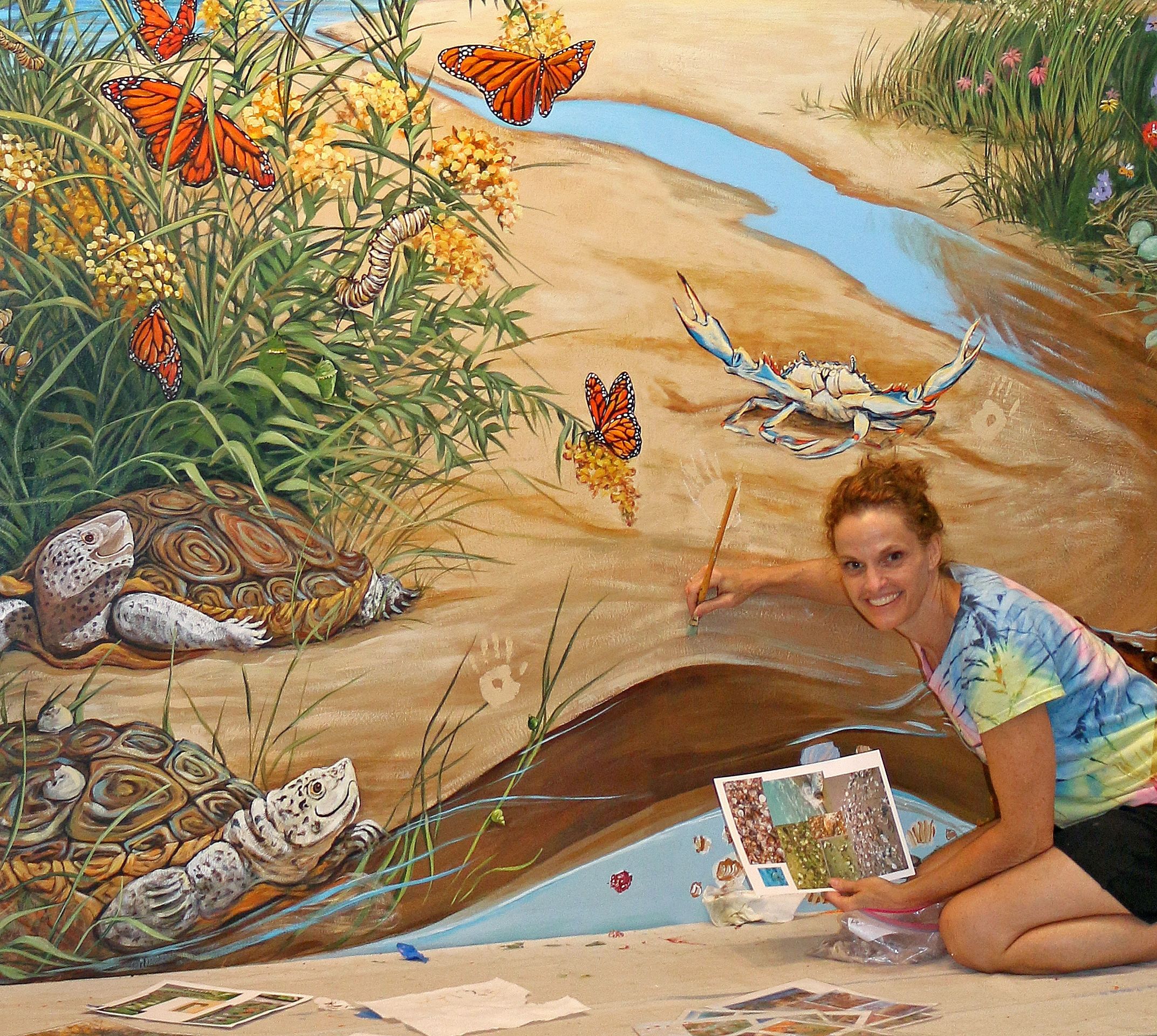 Gayle Mangan Kassal, artist painting custom school mural at Cape St Claire Elementary School.