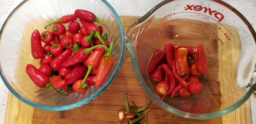 1 bowl of red hot peppers whole.  A measuring cup with chopped peppers.