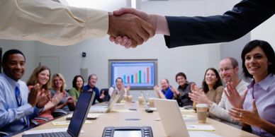 two people shaking hands and people clapping