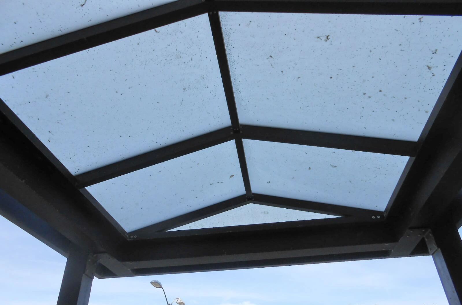Dirty glass roof with metal frame.