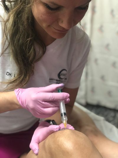 Dr. Abbas treating a patient's knee with prolotherapy on a medical mission trip to Honduras.