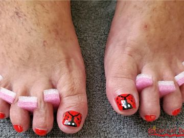 Red polish pedicure with fun lady bugs on big toes