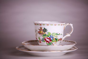 Vintage teacup and plates with colorful flowers and design