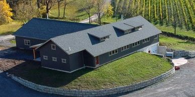 View of back side of winery, showing building set into the hillside with an overhead door for cellar