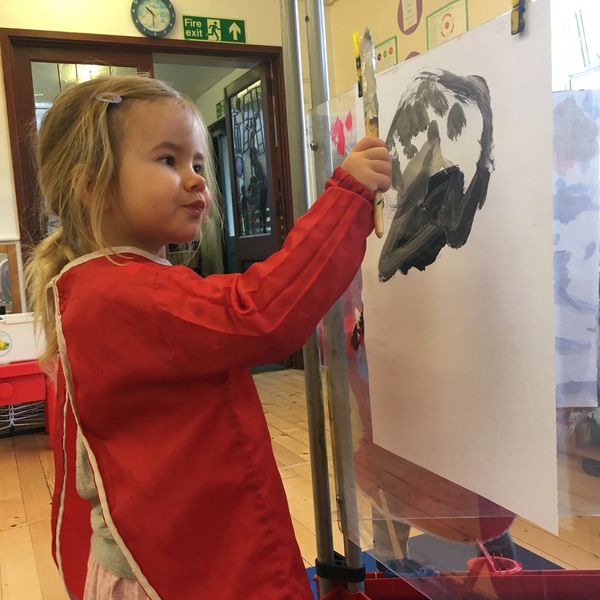 A child painting a picture at playgroup.