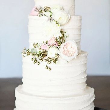 three tier wedding cake with floral arrangement