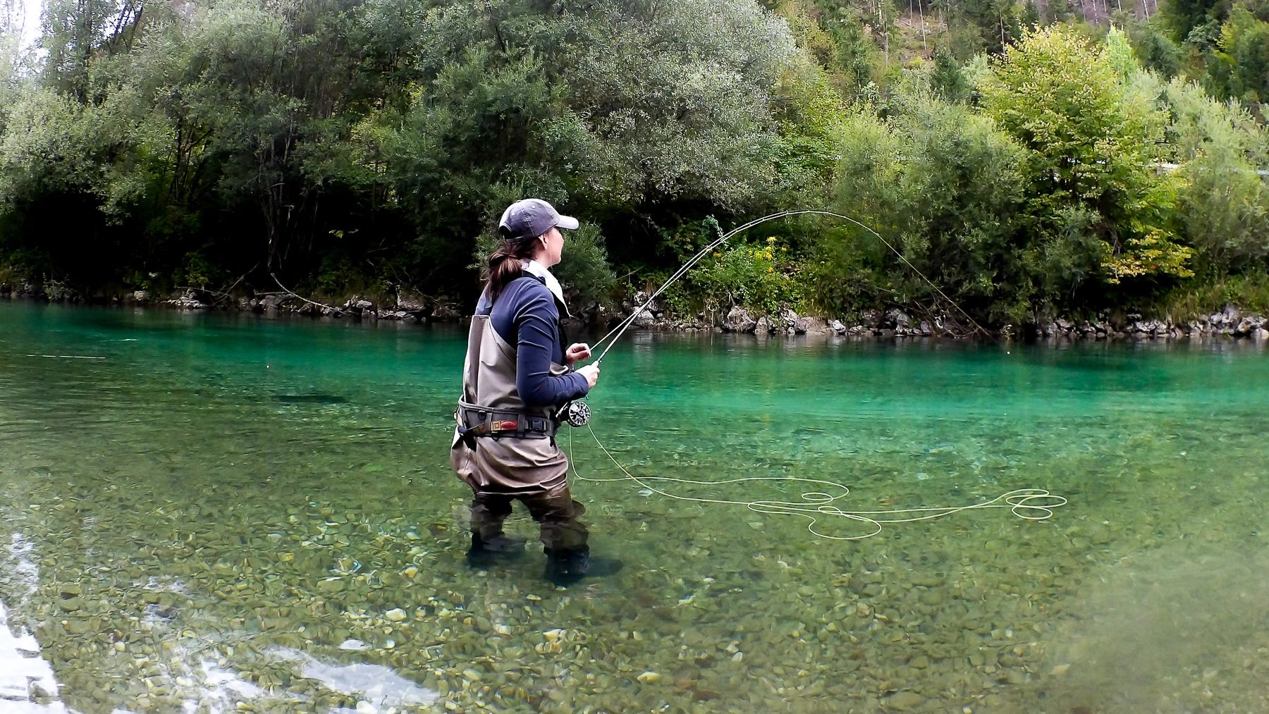Женщина ловит рыбу в Словении в реке, рыбалка нахлыстом