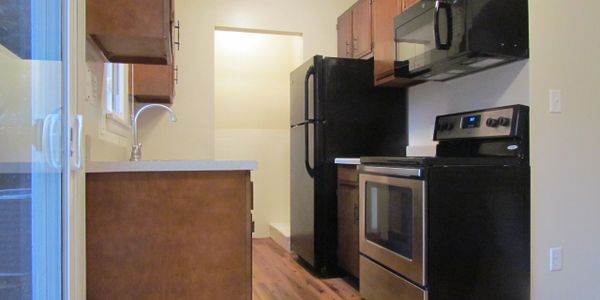 Modern kitchen with black appliances and wooden cabinets.