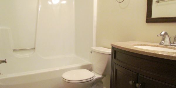 A clean, modern bathroom with a bathtub, toilet, and vanity sink.