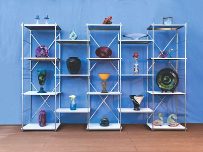 portable metal shelving collapsible bookcase, 10' long by 6' high by 1' deep with art glass on display.  Portable shelf display